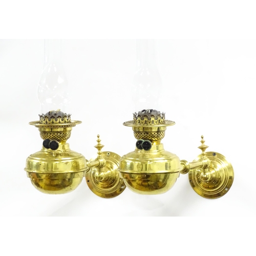 1313 - A pair of early 20thC oil lamps, the adjustable wall mounts supporting duplex burners, each approx 1... 