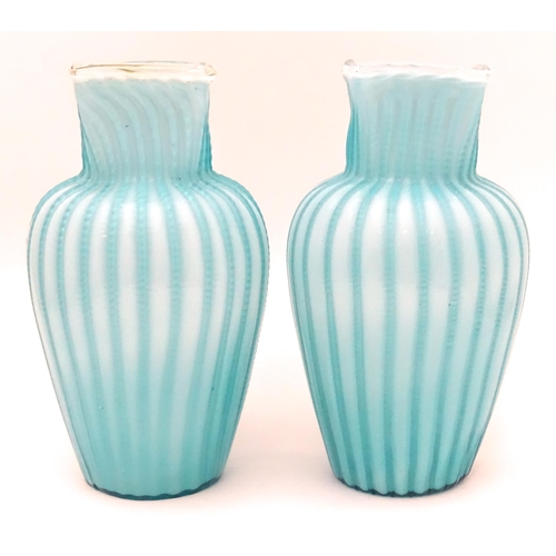 197 - Two turquoise trailed glass vases. Approx 9 1/4