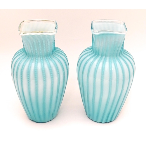 197 - Two turquoise trailed glass vases. Approx 9 1/4