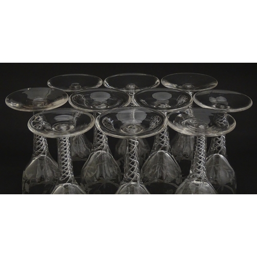 244 - Ten Georgian drinking glasses with air twist detail to stems, the bowls engraved with floral and fol... 