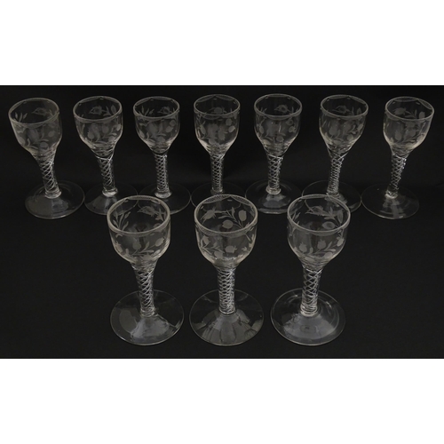 244 - Ten Georgian drinking glasses with air twist detail to stems, the bowls engraved with floral and fol... 