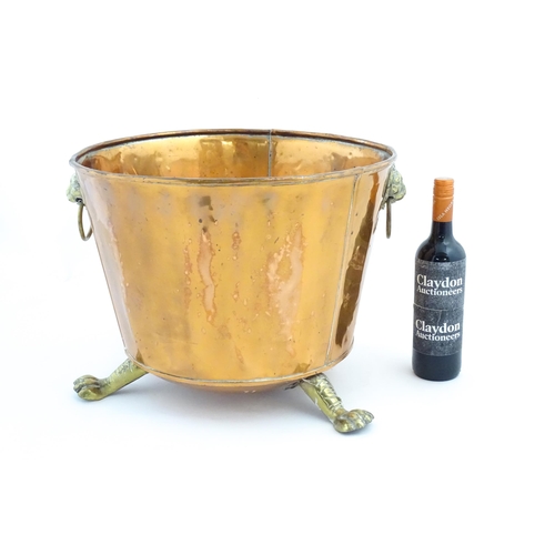 1260 - A late 19th / early 20thC copper log bucket / planter with twin brass lion mask ring handles and thr... 