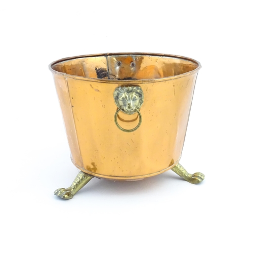 1260 - A late 19th / early 20thC copper log bucket / planter with twin brass lion mask ring handles and thr... 