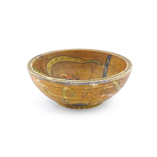 1153 - An early 20thC naive / folk art wooden bowl with hand painted decoration depicting stylised fish and... 