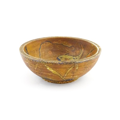 1153 - An early 20thC naive / folk art wooden bowl with hand painted decoration depicting stylised fish and... 