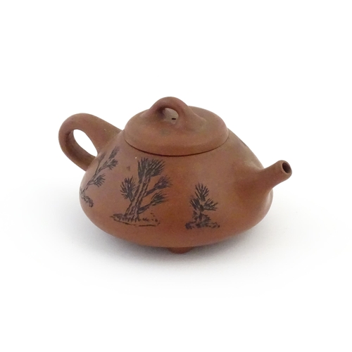 26 - A Chinese Yixing teapot with incised tree and script detail. Character marks under and to underside ... 