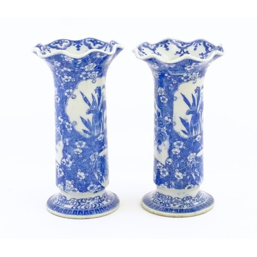 60 - A pair of Oriental blue and white vases with lobed flared rims, decorated with flowers and foliage. ... 