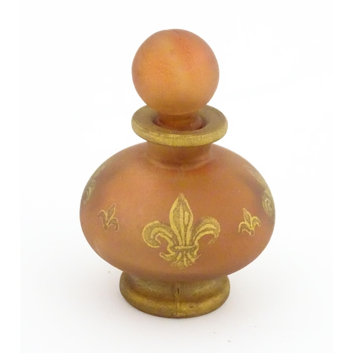 233 - A glass scent / perfume bottle by Jenny Blair with gilt fleur de lys. Approx. 2 3/4