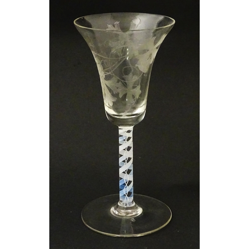 238 - A 19thC pedestal drinking glass with double air twist and etched bird and fruiting vine detail. Appr... 