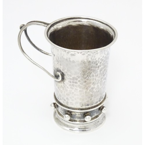 476 - An Arts & Crafts silver christening mug with hammered decoration, banded spherical ball detail and b... 