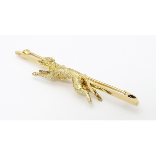 637 - A 9ct gold bar brooch with greyhound / dog detail. Approx. 2 1/4