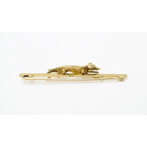 637 - A 9ct gold bar brooch with greyhound / dog detail. Approx. 2 1/4