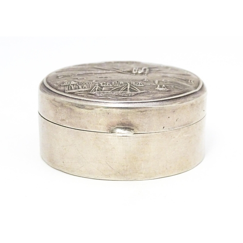 304 - A .925 silver pill box of circular form decorated to lid with images of an aeroplane, airship, boats... 