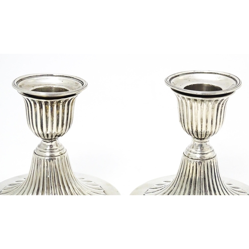 310 - A pair of Victorian short candlesticks with fluted decoration hallmarked Sheffield 1882, maker Elkin... 