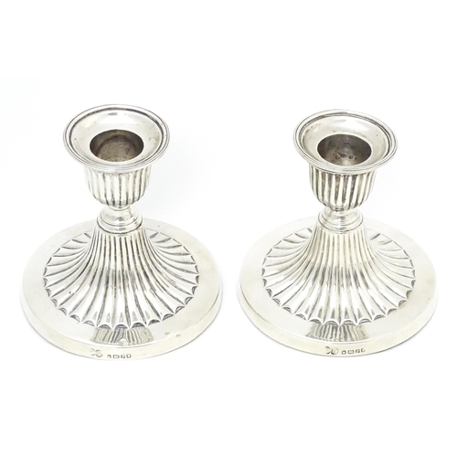 310 - A pair of Victorian short candlesticks with fluted decoration hallmarked Sheffield 1882, maker Elkin... 