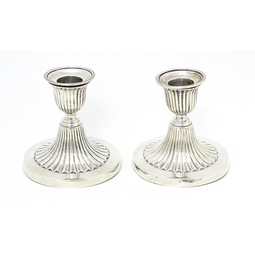 310 - A pair of Victorian short candlesticks with fluted decoration hallmarked Sheffield 1882, maker Elkin... 