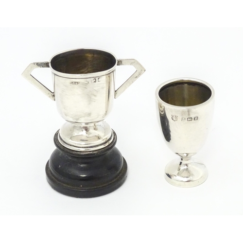 317 - Two miniature silver trophy cups, one with twin handles and a socle base hallmarked Birmingham 1906,... 