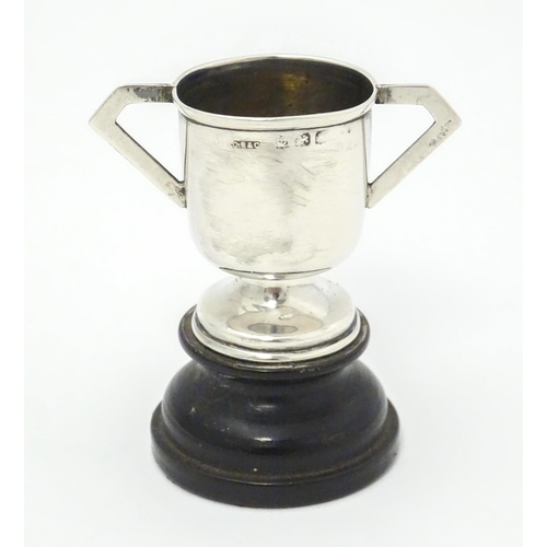 317 - Two miniature silver trophy cups, one with twin handles and a socle base hallmarked Birmingham 1906,... 