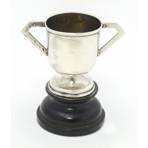 317 - Two miniature silver trophy cups, one with twin handles and a socle base hallmarked Birmingham 1906,... 