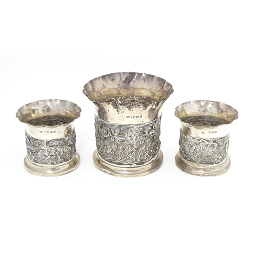 329 - Three Victorian silver bottle coasters with floral scroll and bird detail and flared rims, hallmarke... 