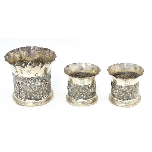 329 - Three Victorian silver bottle coasters with floral scroll and bird detail and flared rims, hallmarke... 