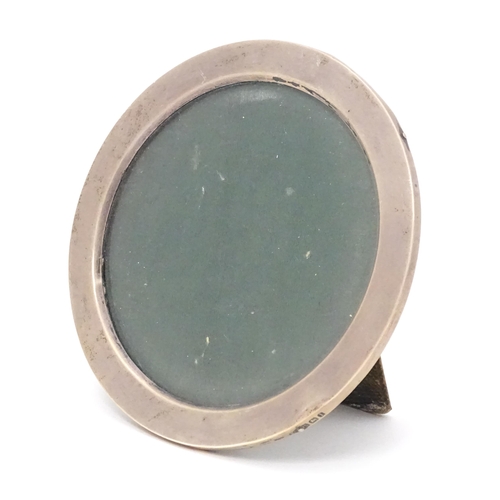 381 - A photograph frame of circular form with silver surround, hallmarked Birmingham 1910. 4 1/2