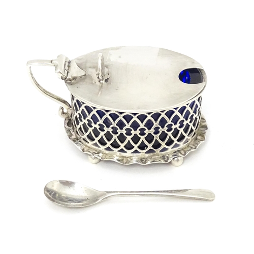 391 - A silver mustard pot of oval form with pierced detail and blue glass liner, hallmarked London 1902.T... 