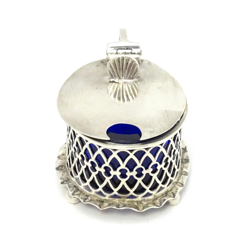 391 - A silver mustard pot of oval form with pierced detail and blue glass liner, hallmarked London 1902.T... 