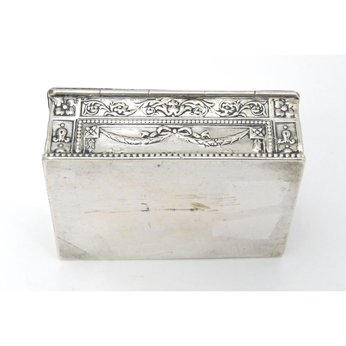 435 - A Continental silver box decorated with cherubs, floral and swag detail and opening to reveal a red ... 