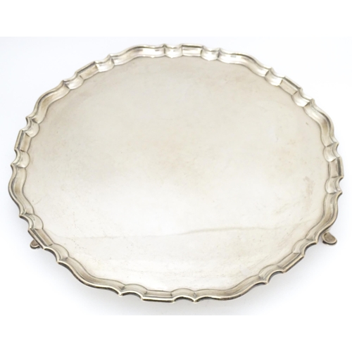 439 - A large silver salver raised on three feet, hallmarked London 1921, maker Hawksworth, Eyre & Co. Ltd... 