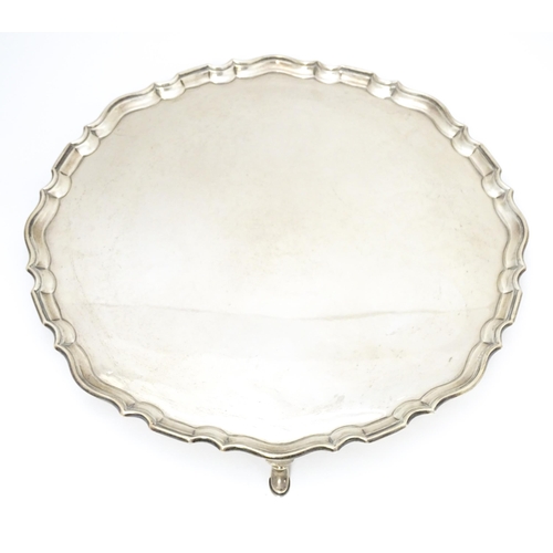 439 - A large silver salver raised on three feet, hallmarked London 1921, maker Hawksworth, Eyre & Co. Ltd... 