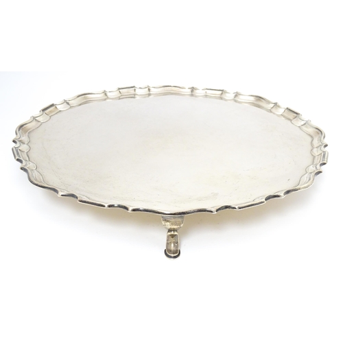 439 - A large silver salver raised on three feet, hallmarked London 1921, maker Hawksworth, Eyre & Co. Ltd... 