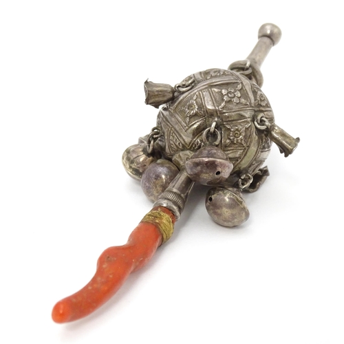 449 - A Continental silver childs rattle with bells, whistle to one end and coral teether to other. Approx... 