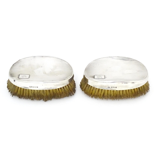 497 - A pair of Art Deco silver backed hair brushes of oval form with engine turned decoration, hallmarked... 