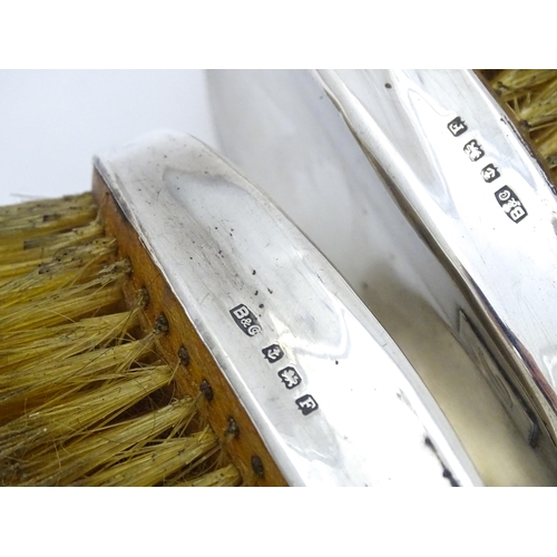 497 - A pair of Art Deco silver backed hair brushes of oval form with engine turned decoration, hallmarked... 