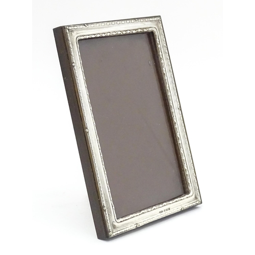 519 - An easel photograph frame with silver surround hallmarked Birmingham 1954, maker W. I. Broadway & Co... 