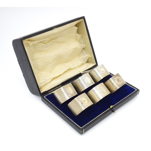 531 - A cased set of six silver napkin rings with engine turned decoration hallmarked Birmingham 1912, mak... 