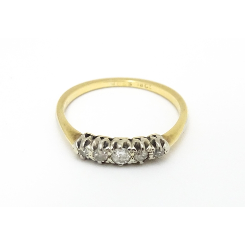 566 - An 18ct gold ring with five diamonds in a linear setting. Ring size approx. O 1/2