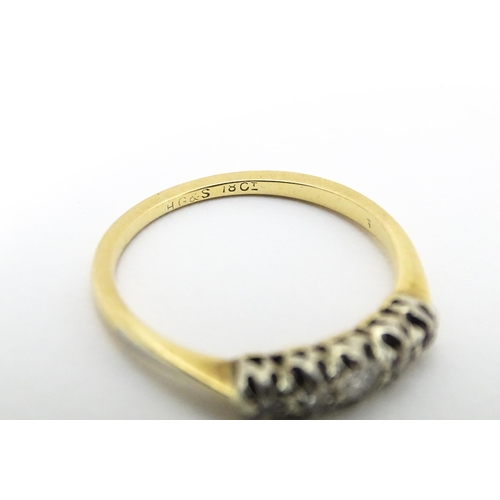 566 - An 18ct gold ring with five diamonds in a linear setting. Ring size approx. O 1/2