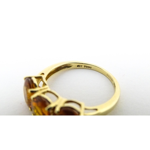 569 - A 9ct gold ring set with three citrine. Ring size approx. L 1/2