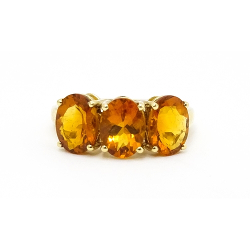 569 - A 9ct gold ring set with three citrine. Ring size approx. L 1/2