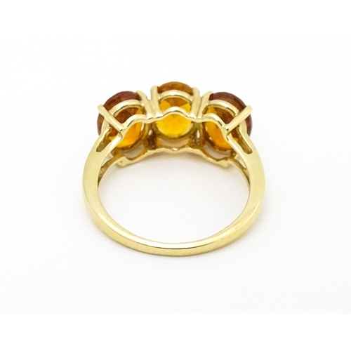 569 - A 9ct gold ring set with three citrine. Ring size approx. L 1/2