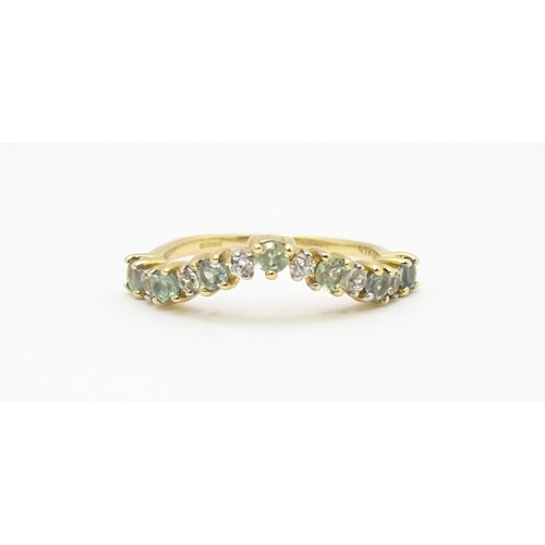 571 - A 9ct gold ring set with green and white stones. Ring size approx. L