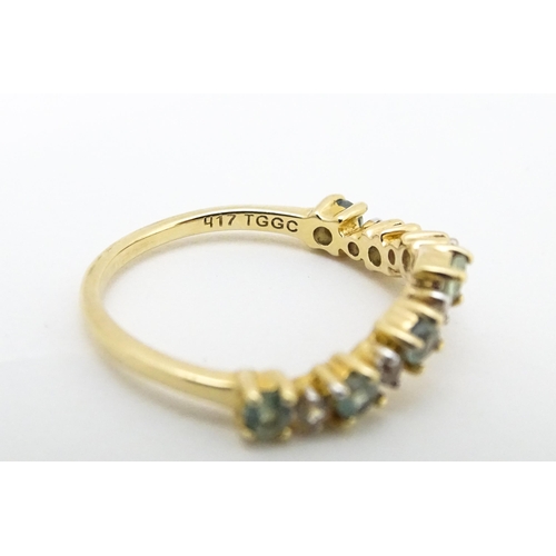 571 - A 9ct gold ring set with green and white stones. Ring size approx. L