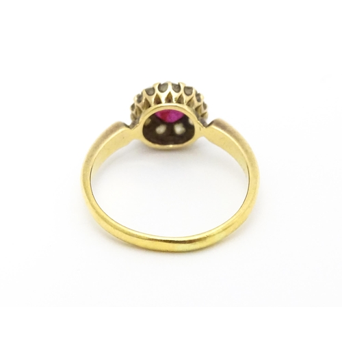 576 - An 18ct gold ring set with central ruby bordered by diamonds. Ring size approx. O 1/2