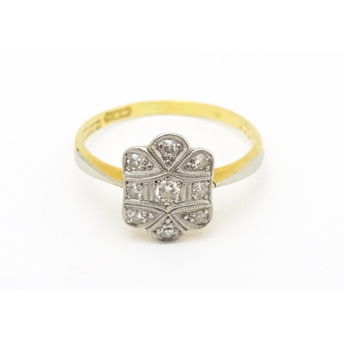 584 - An Art Deco 18ct gold ring with nine platinum set diamonds. Ring size approx. M 1/2