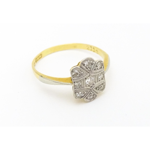 584 - An Art Deco 18ct gold ring with nine platinum set diamonds. Ring size approx. M 1/2