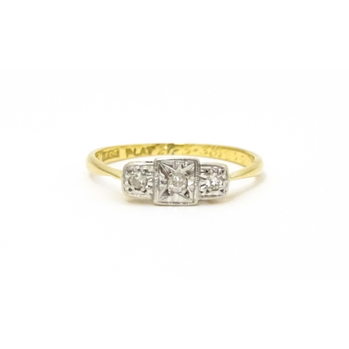 588 - An Art Deco 18ct gold and platinum ring. set with three diamonds. Ring size approx. J.