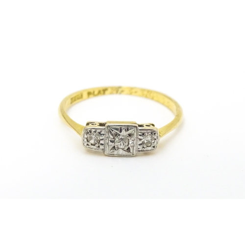 588 - An Art Deco 18ct gold and platinum ring. set with three diamonds. Ring size approx. J.