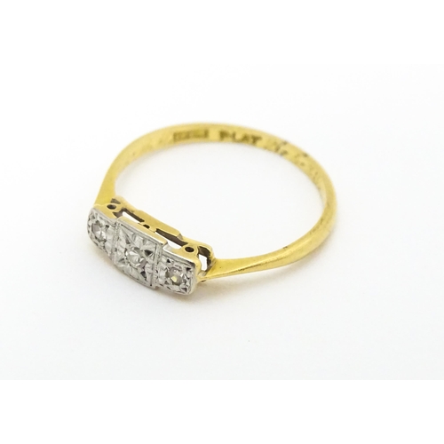 588 - An Art Deco 18ct gold and platinum ring. set with three diamonds. Ring size approx. J.